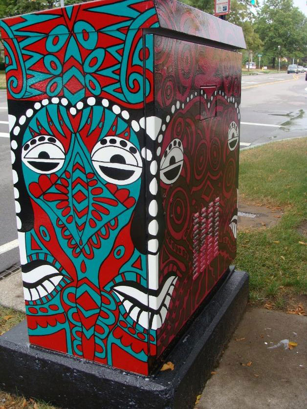 Indonesian Mask Traffic Box at Irondequoit Plaza (Titus Entrance). Part of the Silver Box Project in Irondequoit, NY which transforms traffic signal control boxes into works of art.